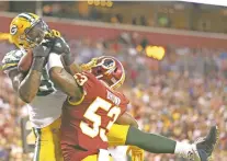  ?? MARK TENALLY/THE ASSOCIATED PRESS ?? Packers tight end Martellus Bennett, left, pulls in a touchdown pass under pressure from Redskins linebacker Zach Brown on Saturday in Landover, Md.