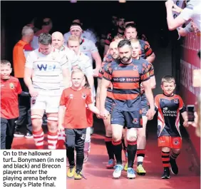  ??  ?? On to the hallowed turf... Bonymaen (in red and black) and Brecon players enter the playing arena before Sunday’s Plate final.