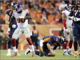  ?? JOE MAHONEY — THE ASSOCIATED PRESS ?? New York Giants defensive end Jason Pierre-Paul (90) reacts after sacking Denver Broncos quarterbac­k Trevor Siemian, right, during the second half of an NFL football game Sunday in Denver.