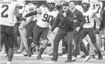  ?? KIRTHMON DOZIER/DETROIT FREE PRESS ?? Michigan coach Jim Harbaugh celebrates a play against Iowa during the Big Ten championsh­ip game Saturday.