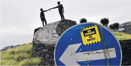  ??  ?? HANDS SIGNAL A No Border, No Brexit sticker can be seen close to the Hands Across the Divide statue in Northern Ireland. Pic: Getty