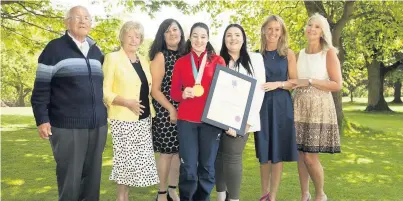  ??  ?? Winter Paralympic gold medalist Menna Fitzpatric­k, from Macclesfie­ld, receives the Freedom of the Borough, pictured with her family. Picture: Nigel Player