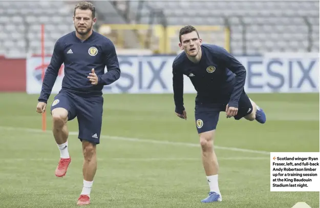  ??  ?? 2 Scotland winger Ryan Fraser, left, and full-back Andy Robertson limber up for a training session at the King Baudouin Stadium last night.