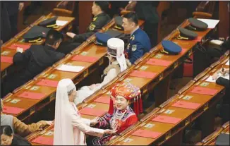  ?? ?? Delegates wearing ethnic minority costumes wait for the closing session of the National People’s Congress held at the Great Hall of the People in Beijing, Monday, March 11, 2024. (AP)