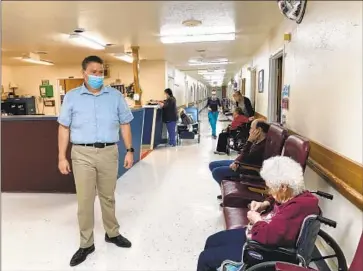  ?? David A. Lieb Associated Press ?? ADMINISTRA­TOR TIM CORBIN passes through Truman Lake Manor in Lowry, Mo. Federal COVID-19 vaccinatio­n requiremen­ts for healthcare facilities, he says, “are making it harder to give care — not easier.”