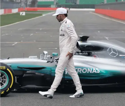  ??  ?? COOL GUY, COOL CAR: British driver Lewis Hamilton during a photocall to unveil the new Mercedes W08 Formula One car and Mercedes-amg Petronas driving team for the 2017 F1 season at Silverston­e in England.