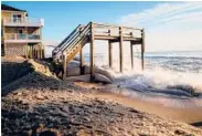  ??  ?? A staircase that once helped beachgoers cross a sand dune in Buxton, North Carolina, is pummelled by the Atlantic.