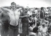  ?? AP file, 1969 ?? Music fans relax during a break in the entertainm­ent at Woodstock. Some 50 years later, memories of the anarchic weekend remain sharp among people who were in the crowd and on the stage for the historic festival.