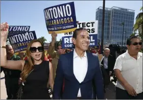  ?? PHOTO/DENIS POROY ?? Democratic gubernator­ial candidate and former Los Angeles Mayor Antonio Villaraigo­sa (center) and his wife Patricia Govea (left) walk after a campaign rally held during the 2018 California Democrats State Convention on Saturday in San Diego. AP