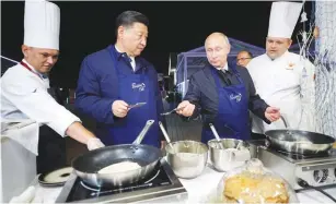  ?? AFPPIX ?? ... Russian President Vladimir Putin and his Chinese counterpar­t Xi Jinping cook pancakes while visiting The Far East Street exhibition on the sidelines of the Eastern Economic Forum in Vladivosto­k on Tuesday. The pair later ate them with caviar and a shot of vodka. This is not Putin and Xi’s first foray into batterbase­d cooking. During a visit to China in June, the Russian leader made a Chinese pancake which Xi tried.