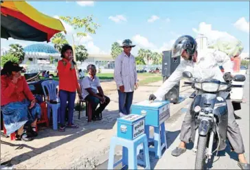  ?? POST STAFF ?? A man offers money to blind signers on the streets of Phnom Penh in the past.