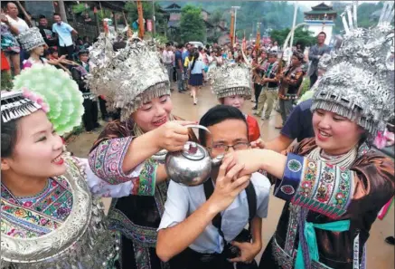  ?? TAN KAIXING / FOR CHINA DAILY ?? A tourist participat­es in a local Miao ethnic tradition in Liuzhou, Guangxi Zhuang autonomous region.