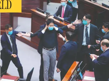  ?? VINCENT YU/THE ASSOCIATED PRESS ?? Pro-democracy lawmaker Hui Chi-fung is warned by security at the main chamber of the Legislativ­e Council in Hong
Kong on Thursday, where a contentiou­s bill making it illegal to insult the Chinese national anthem was approved.