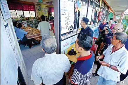  ?? AFP ?? Malaysians stand in a queue to cast their votes at a polling station in Kuching in 2016.