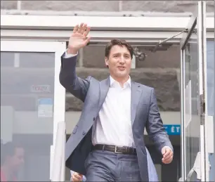  ?? CP PHOTO ?? Prime Minister Justin Trudeau waves to the small crowd gathered in front of city hall as he leaves after participat­ing at a roundtable with local business and union leaders in Alma, Que.