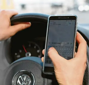  ?? Symbolfoto: Bernhard Weizenegge­r ?? Mit dem Smartphone am Steuer mal eben eine schnelle Nachricht schreiben – immer häufiger werden Verkehrsun­fälle durch Ablenkung des Fahrers verursacht. Kissing