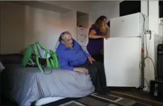  ?? JOHN LOCHER — THE ASSOCIATED PRESS ?? Celeste Mills loads food into a refrigerat­or as Gordon Lamb looks on at their room in a weekly rental motel in Reno, Nev., earlier this month.