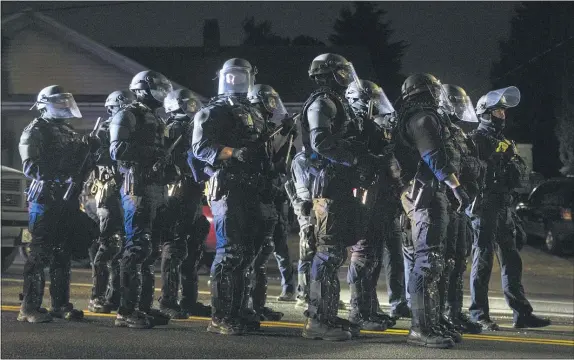  ?? PAULA BRONSTEIN — THE ASSOCIATED PRESS ?? Portland police take control of the streets after making arrests on the scene of the nightly protests at a Portland police precinct on Sunday. Oregon State Police will return to Portland to help local authoritie­s after the fatal shooting of a man following clashes between President Donald Trump supporters and counter-protesters that led to an argument between the president and the city’s mayor over who was to blame for the violence.