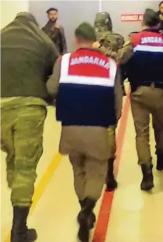  ?? FOTO: AP ?? Türkische Polizisten führen die griechisch­en Soldaten Angelos Mitretodis und Dimitris Kouklatzis in Edirne ab.