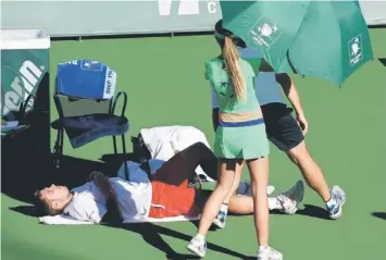  ??  ?? Stanislas Wawrinka of Switzerlan­d lies on the court to recieve treatment from a trainer during his match against Kevin Anderson of South Africa during the BNP Paribas Open at Indian Wells Tennis Garden in Indian Wells, California. — AFP photo