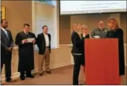  ?? DAN SOKIL - DIGITAL FIRST MEDIA ?? New Hatfield police Officer Brandi McCoy, center, is sworn in by District Judge Andrea Duffy, right, as family members and township officials look on during the township commission­ers’ meeting Wednesday.