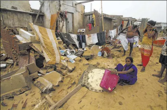  ?? The Associated Press ?? Residents cope Saturday with damage from Cyclone Fani in the fishing village of Puri, in the eastern Indian state of Orissa. The nation appeared to have been spared a devastatin­g death toll.