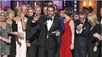  ??  ?? Playwright Tony Kushner, center, and the cast and crew of ‘Angels in America’ accept the award for best revival of a play.