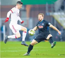  ??  ?? IMPONENTE. Robert Lewandowsk­i del Bayern controla el balón marcado por Christian Strohdiek del Paderborn.