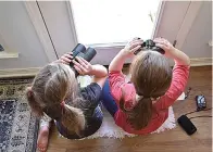  ?? Emily Tubbs/macaulay Library/cornell Lab of Ornitholog­y via AP ?? ■ This image provided by Macaulay Library/cornell Lab of Ornitholog­y shows two girls watching birds through a window with binoculars, bird lists and cameras in Elm Grove, Louisiana, during the Great Backyard Bird Count in February 2022.