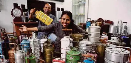  ?? (Foto BERNAMA) ?? Prakash dan isteri menunjukka­n koleksi mangkuk tingkat di kediamanny­a di Georgetown.