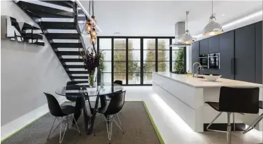  ??  ?? This basement conversion in a mews house comprises an open-plan kitchen and living area with bi-fold doors opening out to a small garden that’s actually a light well, covered with reinforced glass above, by Simply Basement