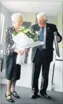  ??  ?? Bill Bly, representi­ng the Manawatu¯ Cancer Society, presents Barbara Day with her Life Membership and flowers on Saturday November 24 at Bush Multi-Sport.