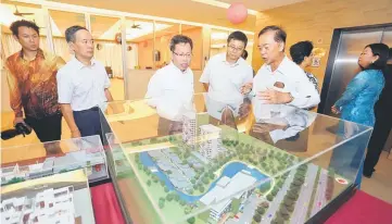  ??  ?? Fong (right) briefs Fu (second right) and Dr Sim (third right) on the developmen­t of Eden on the Park.