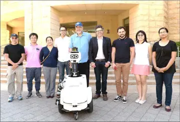  ?? — Photo by Amanda Law ?? The project team with JackRabbot 2 (from left): Patrick Goebel, Noriaki Hirose, Tin Tin Wisniewski, Amir Sadeghian, Alan Federman, Silvio Savarese, Roberto Martín-Martín, Pin Pin Tea-mangkornpa­n and Ashwini Pokle.