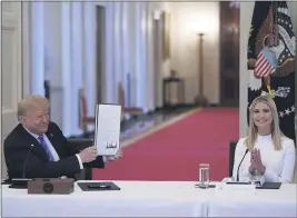  ?? EVAN VUCCI — THE ASSOCIATED PRESS FILE ?? Ivanka Trump, right, applauds as President Donald Trump holds an executive order that he signed during a meeting with the American Workforce Policy Advisory Board in the East Room of the White House in Washington on June 26.