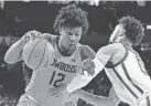  ?? SUE OGROCKI/AP ?? OSU forward Matthew-Alexander Moncrieffe (12) drives against OU guard Jordan Goldwire on Feb. 26.