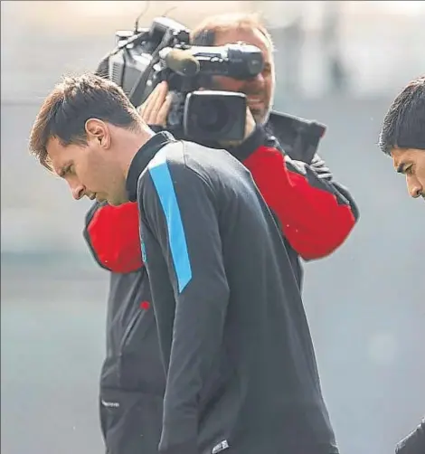  ??  ?? Lionel Messi y Luis Suárez entrando en el campo de entrenamie­nto, ayer