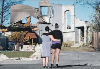  ?? Michael Owen Baker For The Times ?? NEIGHBORS ROSALIA SCHMIDT and Pamela Hardine, right, look at a razed house Saturday on Stone Ridge Court in Santa Clarita. Schmidt’s and Hardine’s homes were not burned in the Tick fire.