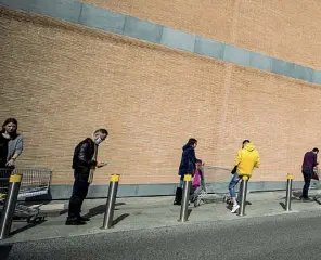  ?? (foto Carconi/Ansa) ?? Viale Palmiro Togliatti La fila per fare la spesa ieri mattina