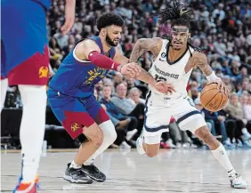  ?? DAVID ZALUBOWSKI THE ASSOCIATED PRESS FILE PHOTO ?? Memphis Grizzlies guard Ja Morant drives against Denver Nuggets guard Jamal Murray last Friday in Denver. The NBA is investigat­ing a social media post in which Morant appeared to be holding a gun.