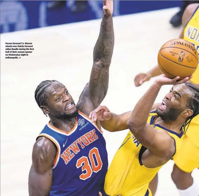  ?? AP ?? Pacers forward T.J. Warren shoots over Knicks forward Julius Randle during the first half of their season opener on Wednesday night in Indianapol­is.