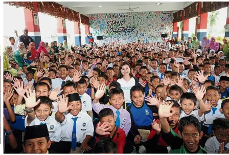  ??  ?? Lisa (standing in the middle) with the pupils from SK Kota Dalam in Ayer Hitam, which were among the winners of the #StandToget­her “kindness project” competitio­n.