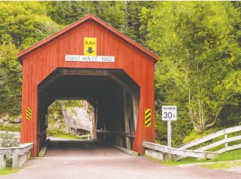  ??  ?? This red wooden covered bridge can be found on a remote road in New Brunswick’s Fundy National Park.