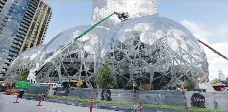  ?? ELAINE THOMPSON/THE ASSOCIATED PRESS ?? Three glass-covered domes are part of an expansion of the Amazon campus in Seattle. Amazon says it will spend more than $5 billion to build a second headquarte­rs in North America that would employ 50,000 at an average salary of more than $100,000.