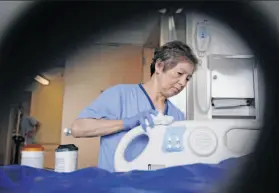  ?? Photos by Lea Suzuki / The Chronicle ?? Rosita Saavedra uses Sani-Cloth wipes after a change from disposable alcohol wipes to non-alcohol, non-bleach wipes at UCSF Medical Center at Parnassus.