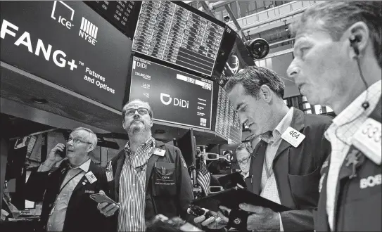  ?? BRENDAN MCDERMID / REUTERS ?? Traders work during the launch of the initial public offering by Chinese ride-hailing company Didi Global on the New York Stock Exchange on June 30.