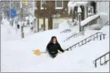  ?? GREG WOHLFORD — ERIE TIMES-NEWS VIA ASSOCIATED PRESS ?? Rochelle Carlotti, 28, shovels steps near her home after a record snowfall on Tuesday in Erie, Pa. The National Weather Service office in Cleveland says Monday's storm brought 34 inches of snow, a daily snowfall record for Erie.