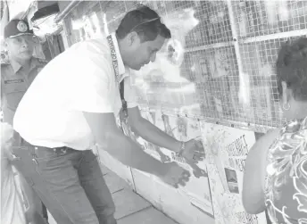  ?? LALAINE M. JIMENEA ?? Ormoc City Mayor Richard Gomez personally removes cigarette advertisin­g posters from stores nearby the school and barangay hall of Canadieng. The mayor lives in the same barangay.