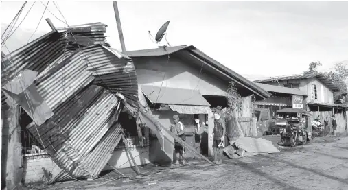  ??  ?? RESIDENTS stand next to a house damaged by typhoon Phanfone in Ormoc City. Typhoon Phanfone pummeled the Central Philippine­s bringing a wet, miserable and terrifying holiday season to millions in the mainly Catholic nation.