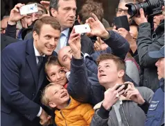  ?? — AFP, AP ?? French presidenti­al candidate Emmanuel Macron (left) poses for a selfie with supporters after voting in Le Touquet, northern France, and far-right presidenti­al candidate Marine Le Pen (right) before casting her ballot in Henin Beaumont on Sunday,...